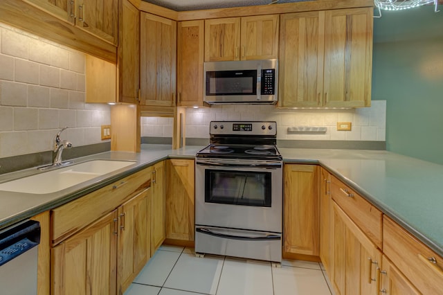 kitchen featuring decorative backsplash, sink, light tile patterned floors, and stainless steel appliances