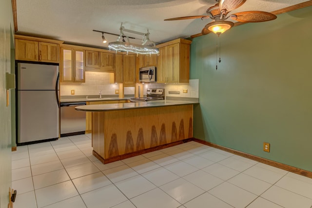 kitchen with kitchen peninsula, decorative backsplash, a textured ceiling, and stainless steel appliances