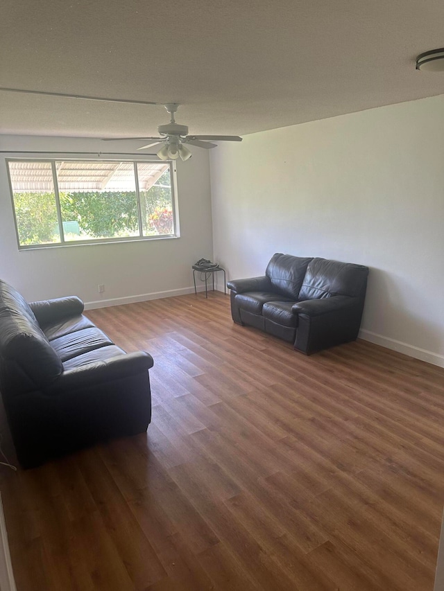 living room with ceiling fan and dark hardwood / wood-style flooring