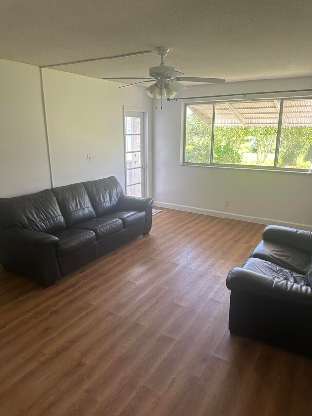 living room featuring wood-type flooring and ceiling fan