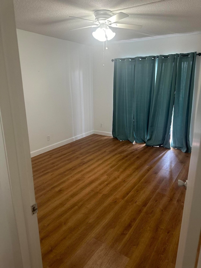 unfurnished room with a textured ceiling, hardwood / wood-style flooring, and ceiling fan