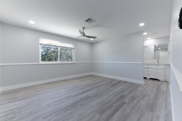 spare room featuring ceiling fan, sink, and light hardwood / wood-style floors