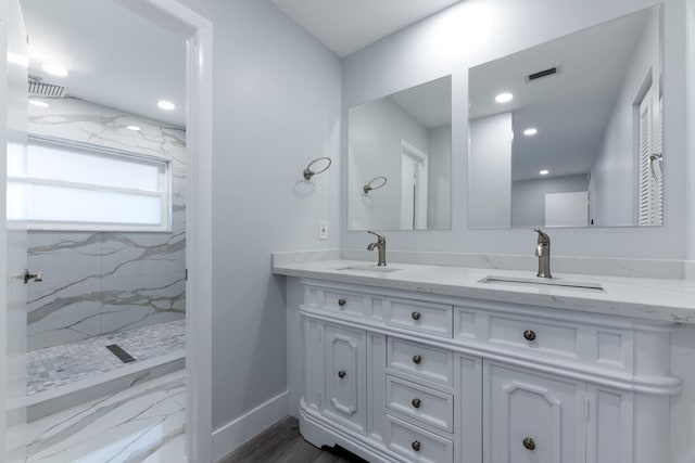 bathroom with vanity, hardwood / wood-style flooring, and tiled shower