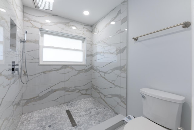 bathroom featuring tiled shower and toilet