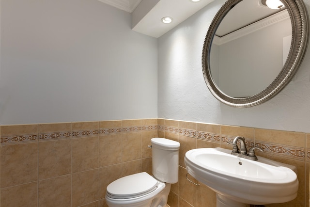 bathroom with sink, crown molding, tile walls, and toilet