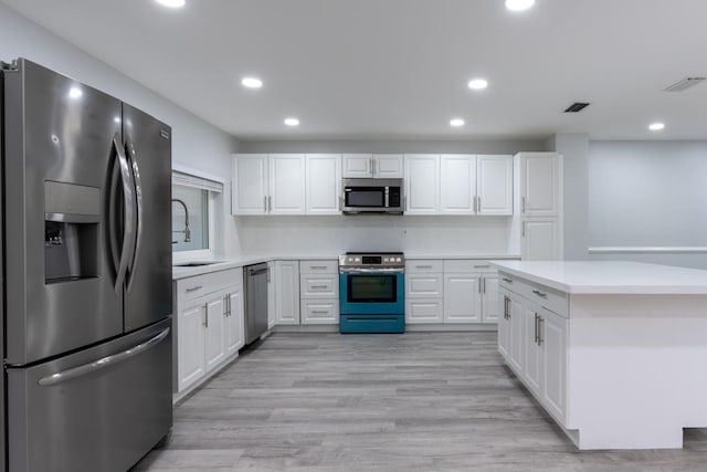 kitchen featuring light hardwood / wood-style flooring, sink, stainless steel appliances, and white cabinets