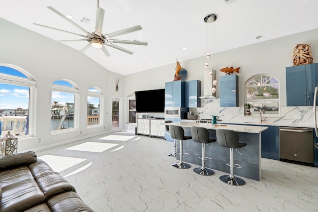 kitchen featuring a center island, tasteful backsplash, blue cabinets, and a breakfast bar area