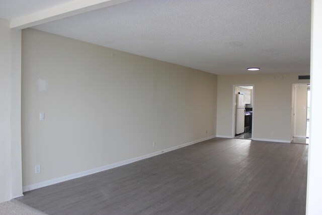 spare room featuring dark wood-type flooring, sink, and a textured ceiling