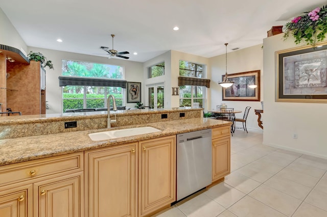 kitchen featuring plenty of natural light, sink, stainless steel dishwasher, and hanging light fixtures