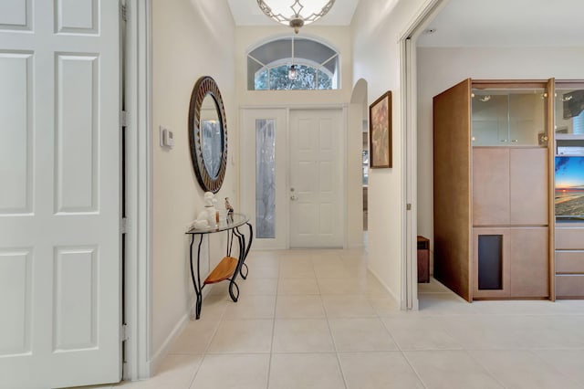 foyer entrance with vaulted ceiling and light tile patterned floors