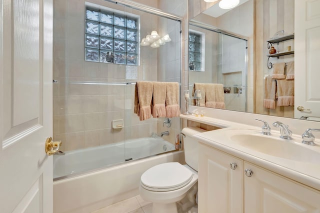 full bathroom featuring vanity, combined bath / shower with glass door, toilet, and tile patterned flooring