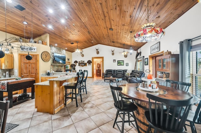 tiled dining area with a fireplace, high vaulted ceiling, and wooden ceiling