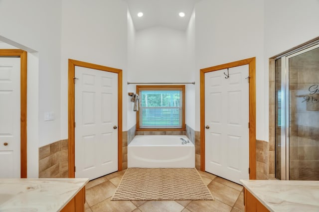 bathroom with tile patterned flooring, shower with separate bathtub, vanity, and high vaulted ceiling