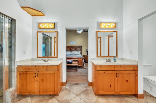 bathroom with tile patterned flooring, vanity, toilet, and ceiling fan