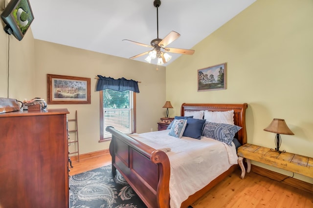 bedroom with ceiling fan, lofted ceiling, and light wood-type flooring