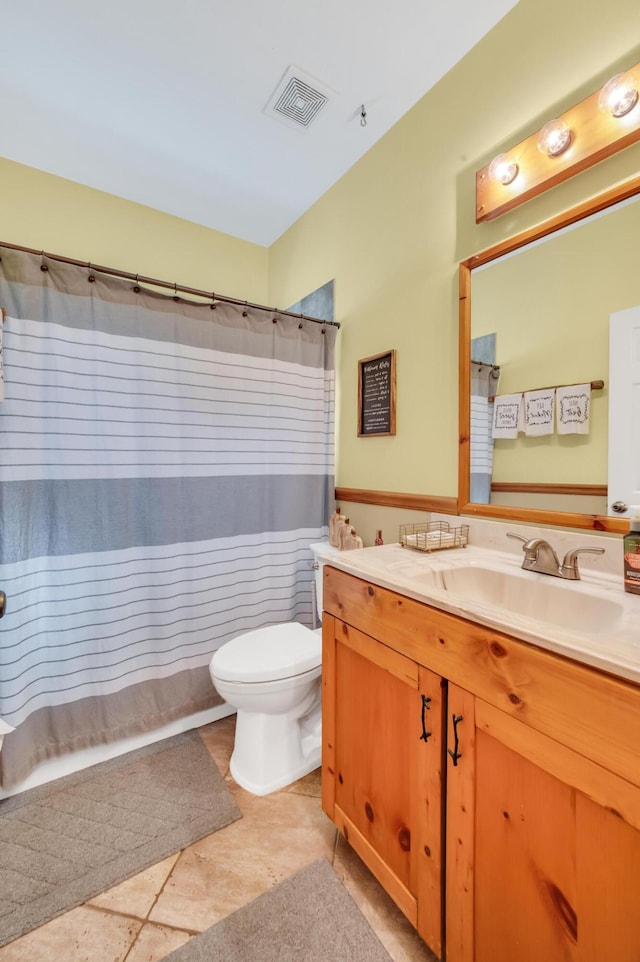 bathroom featuring tile patterned floors, vanity, a shower with shower curtain, and toilet