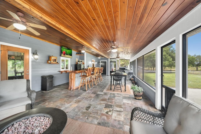 sunroom / solarium with bar area, ceiling fan, and wooden ceiling