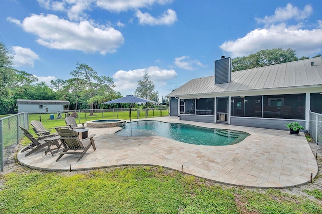 view of swimming pool featuring a sunroom, a yard, an in ground hot tub, a patio area, and an outdoor fire pit