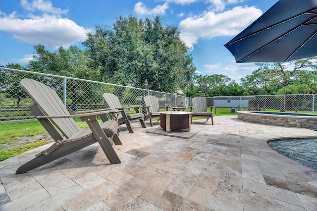 view of patio featuring a fire pit and a pool with hot tub