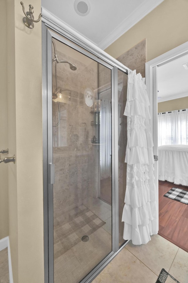 bathroom featuring crown molding, wood-type flooring, and an enclosed shower