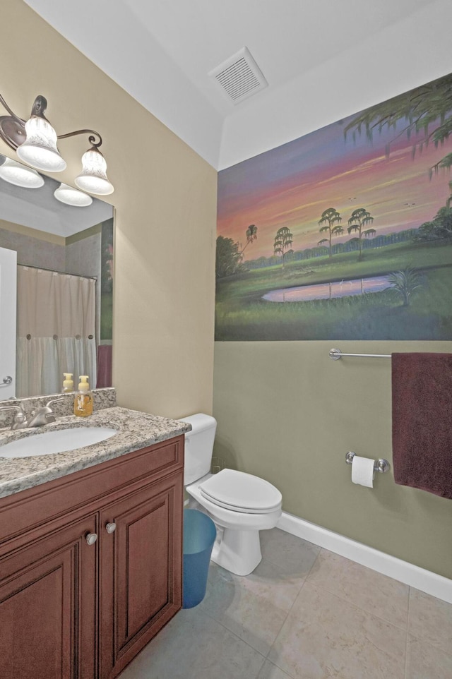 bathroom featuring tile patterned flooring, vanity, toilet, and walk in shower