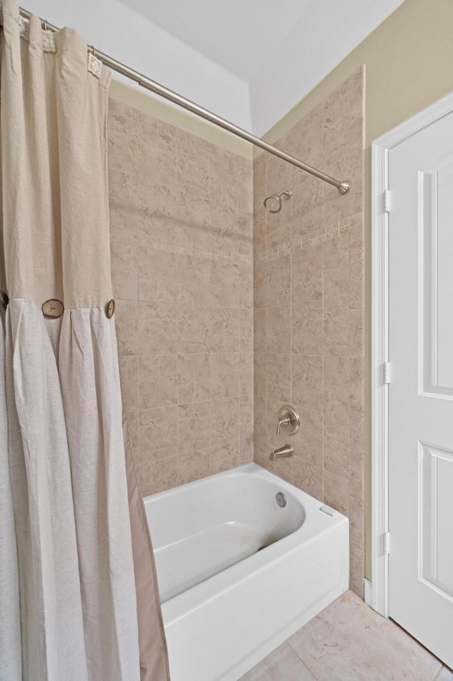 bathroom with tile patterned floors and shower / bath combo with shower curtain