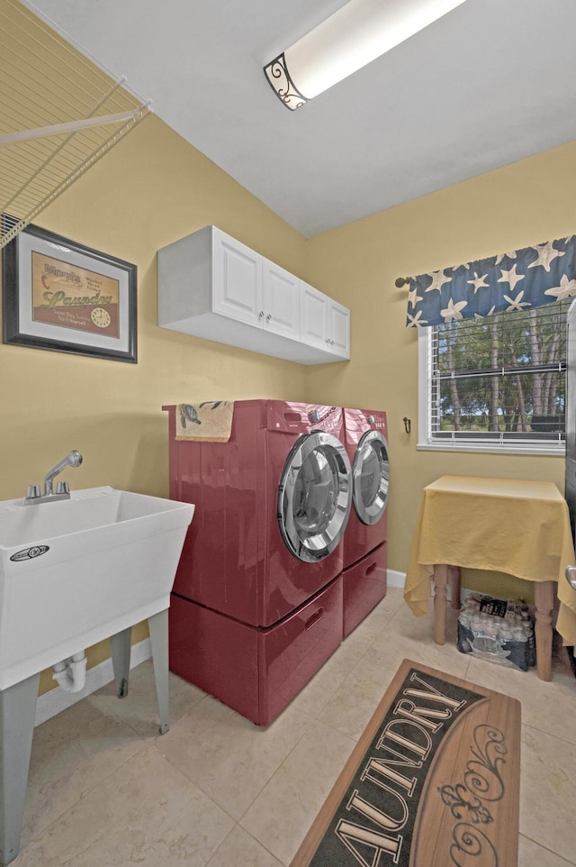 laundry area with light tile patterned flooring, cabinets, and independent washer and dryer