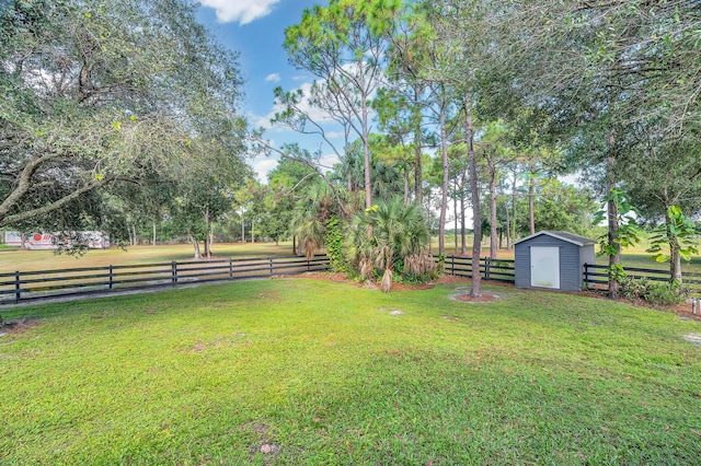 view of yard featuring a rural view and a storage unit