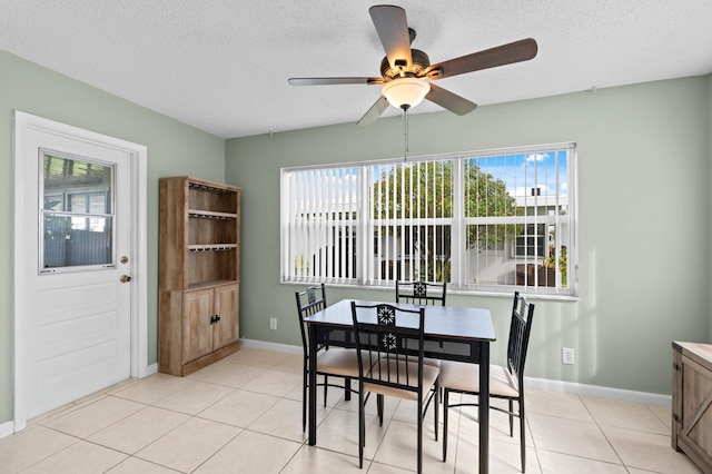 tiled dining room featuring ceiling fan and a textured ceiling