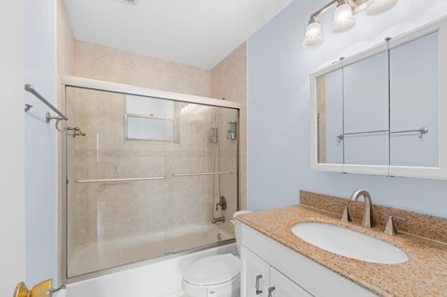 full bathroom with vanity, enclosed tub / shower combo, and toilet