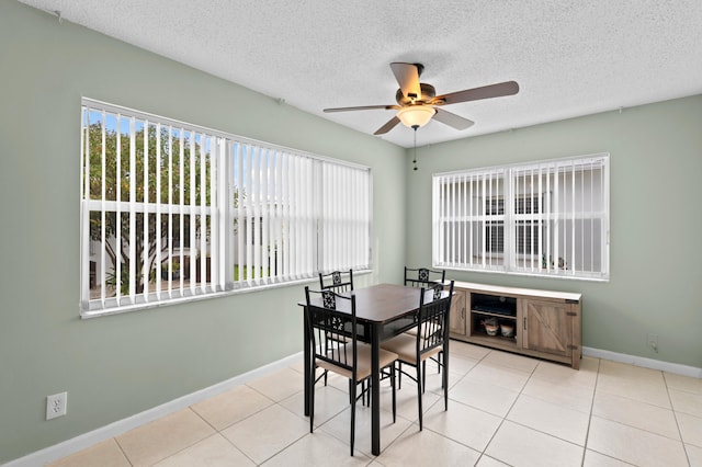 dining room with a textured ceiling, light tile patterned floors, and ceiling fan