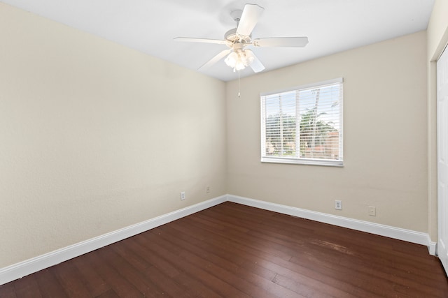 empty room with dark hardwood / wood-style floors and ceiling fan