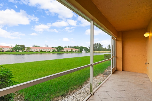 unfurnished sunroom featuring a water view