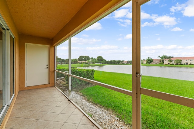 unfurnished sunroom featuring a water view