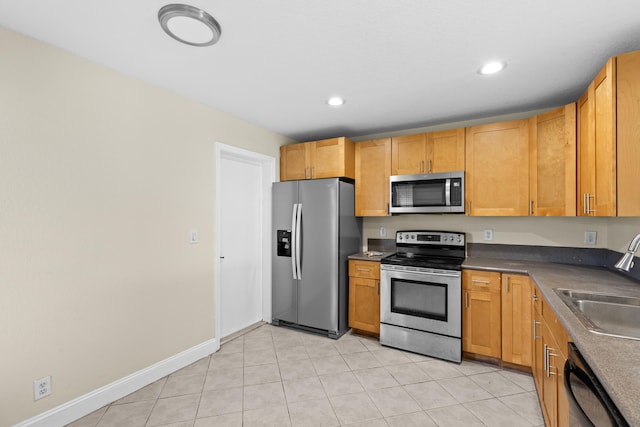 kitchen with light tile patterned flooring, appliances with stainless steel finishes, and sink