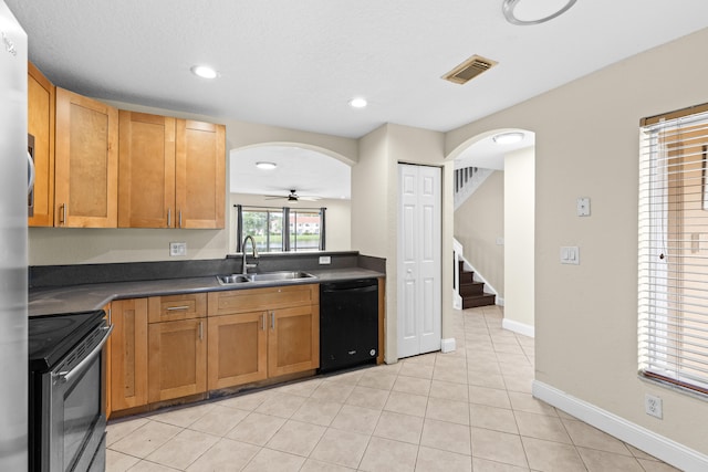 kitchen featuring sink, ceiling fan, light tile patterned floors, black dishwasher, and range