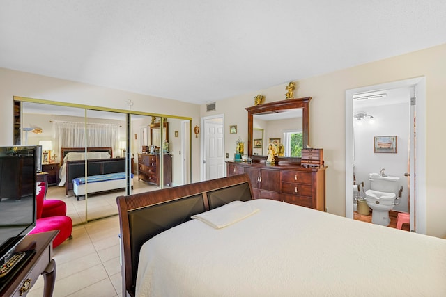 tiled bedroom featuring a closet and connected bathroom