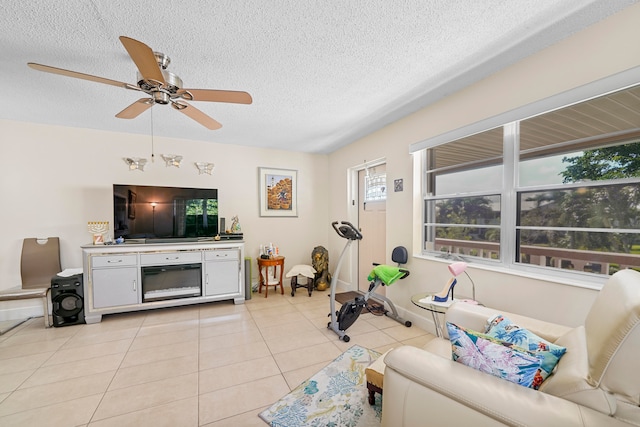 living room with ceiling fan, a textured ceiling, and light tile patterned floors