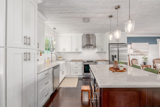 kitchen with white cabinets, stainless steel appliances, wall chimney exhaust hood, and a center island