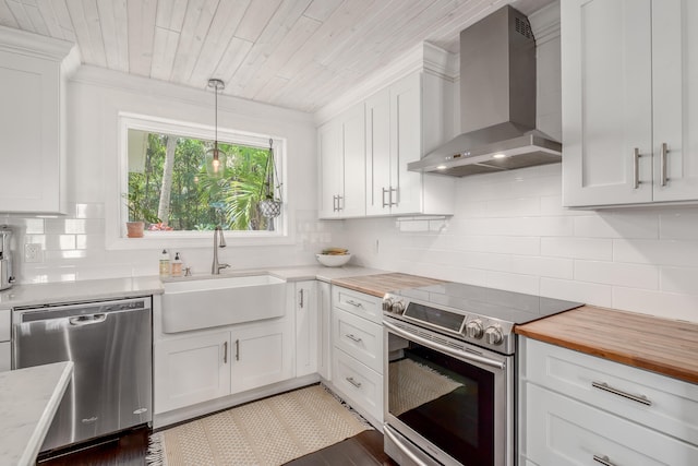 kitchen featuring dark hardwood / wood-style flooring, wall chimney range hood, stainless steel appliances, and white cabinets