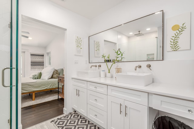 bathroom featuring wood-type flooring, vanity, and a shower with shower door