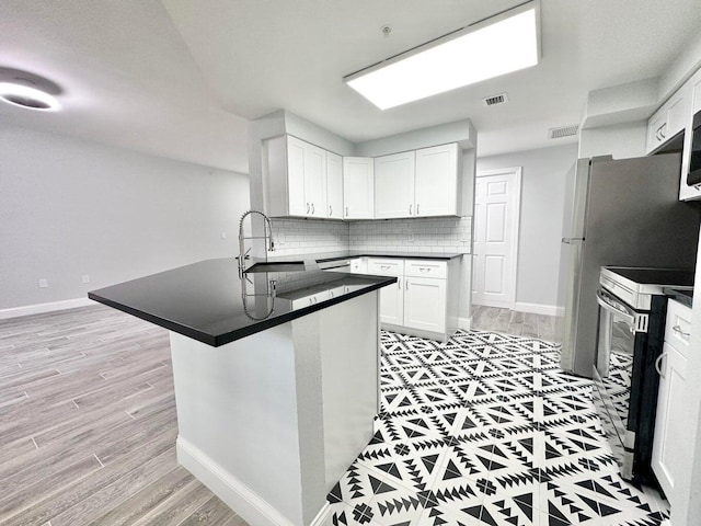 kitchen featuring white cabinetry, decorative backsplash, sink, kitchen peninsula, and stainless steel electric range oven