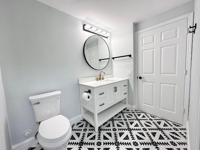 bathroom featuring toilet, vanity, and a textured ceiling