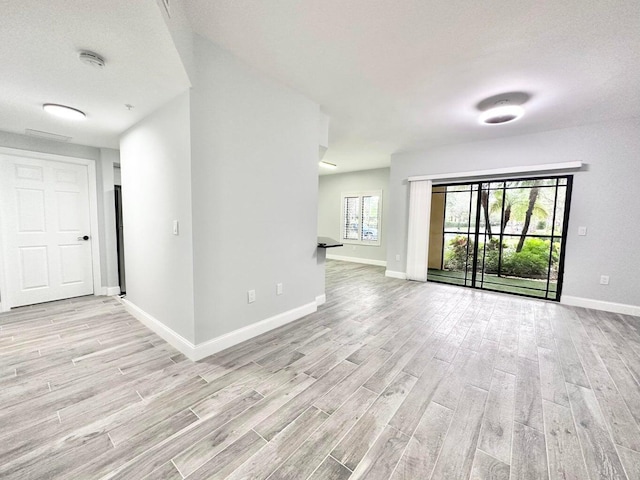 empty room featuring a wealth of natural light and light wood-type flooring