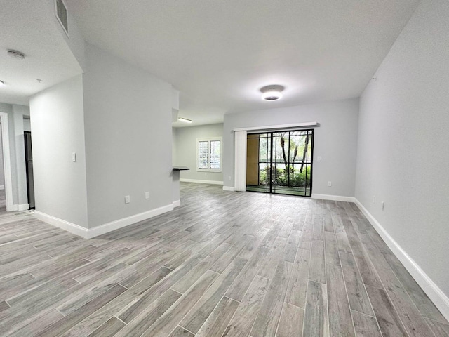 spare room with a textured ceiling and light hardwood / wood-style floors