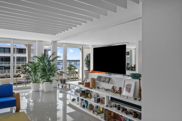 living room with beam ceiling and floor to ceiling windows