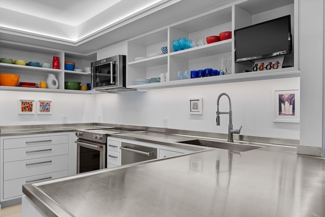 kitchen featuring open shelves, a sink, stainless steel appliances, stainless steel counters, and white cabinetry