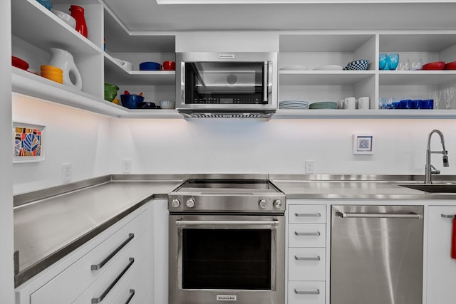 kitchen with stainless steel countertops, white cabinetry, open shelves, and stainless steel appliances