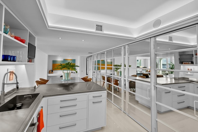 kitchen featuring white cabinets, sink, and stainless steel counters