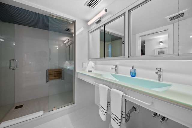 bathroom featuring tile patterned flooring, an enclosed shower, and vanity